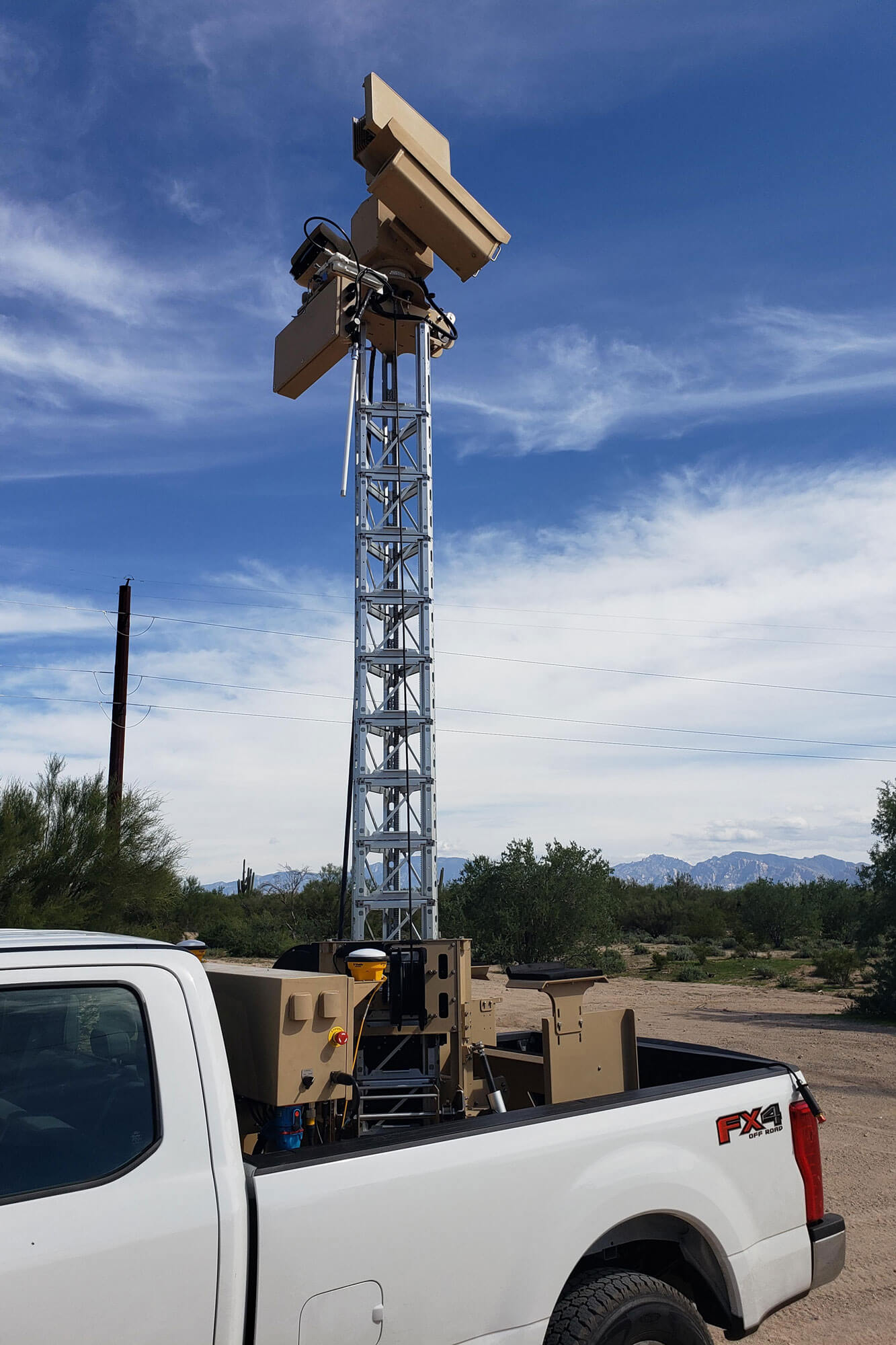 Tower in bed of truck with surveillance equipment